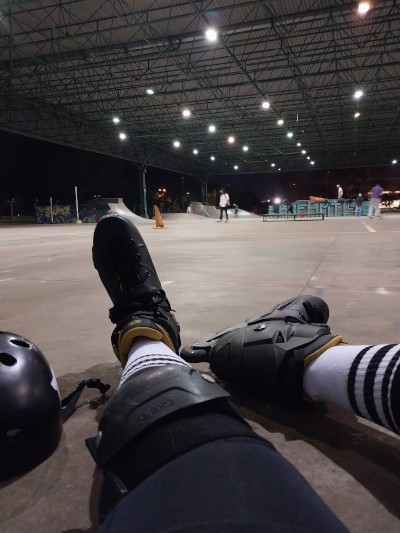 foto de uma pessoa vestindo patins ao fundo uma pista de patinação