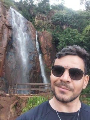 Foto minha com uma cachoeira no fundo